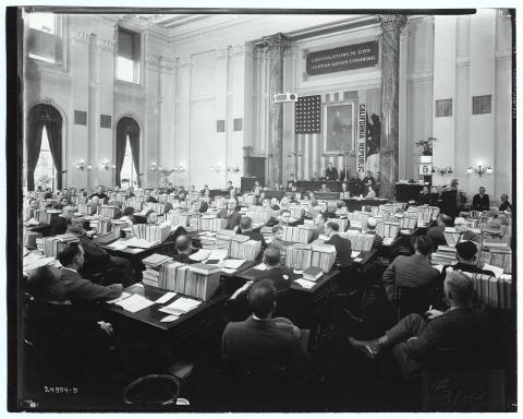 Photo of Harvey S. Firestone, Sr. addressing the State Assembly in  session on April 5, 1929. Speaker Edgar Levey present at rostrum. Members are seated at their desks, which are piled with paperwork and books.