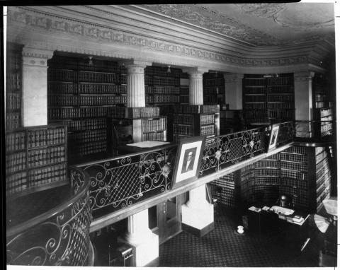 Photo of interior of State Library when it was housed in the State Capitol apse. Photo shows book stacks and two levels of library.