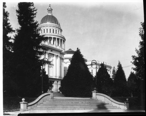 View of the State Capitol from the southeast (approx. 12th and N Streets), showing large staircase leading up the terraced grounds of Capitol Park toward Capitol building. Circa 1940.