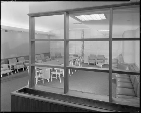 View of the new Assembly Member’s lounge, circa 1952. Pictured:  long conference table with ashtrays, upholstered bench booth seating in 1950s style. Located on the Third Floor annex behind the Assembly Chamber. The lounge is where the majority party holds caucus meetings during floor sessions (black and white photo).