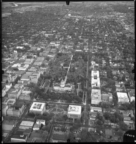 Aerial view of Capitol and downtown Sacramento, circa 1948. Visible are homes, businesses, and office buildings.  Construction of annex to 1100 N Street state office building is visible to the south of the Capitol.  Also visible: entire Capitol Park; Senator Hotel; gas station at 13th and L Streets; a circular drive-in restaurant at 16th &amp; K Streets;  Memorial Auditorium;  and the Alhambra Theatre in the distance. (black and white photo).